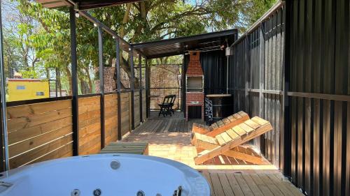 eine Terrasse mit einer Badewanne und einer Bank in der Unterkunft Minicasa Brasileira in Sorocaba
