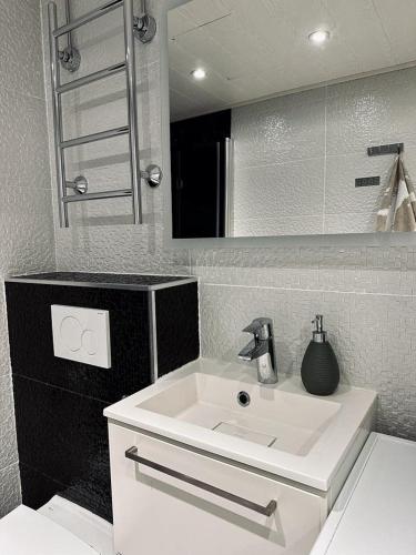 a bathroom with a white sink and a mirror at Moderni yksiö parvekkeella,, erinomainen sijainti in Helsinki