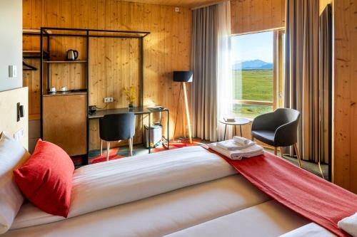 a large bed with a red blanket on top of it at Landhotel in Hella