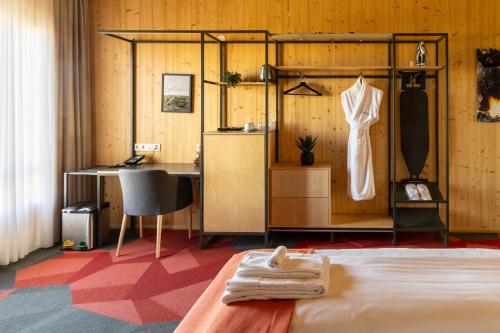 海拉的住宿－Landhotel，一间卧室,配有一张床,衣架上挂着一束衣服