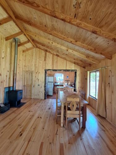 a room with a table and a stove in a cabin at Cabañas piedra Alta, Huilo Huilo in Panguipulli