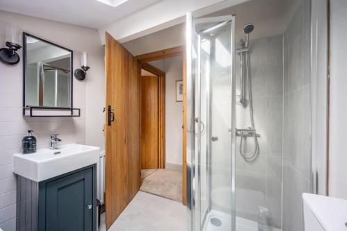 a bathroom with a sink and a shower at Annie's Cottage - Big Skies Holiday Cottages in Sharrington