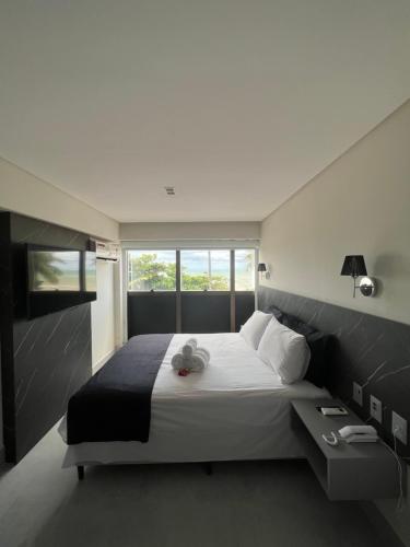 a bedroom with a large bed and a window at Flat ARPOAR Suítes Manaíra com vista para o mar in João Pessoa