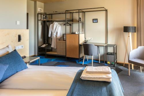 a bedroom with a bed and a desk and a dressing room at Landhotel in Hella