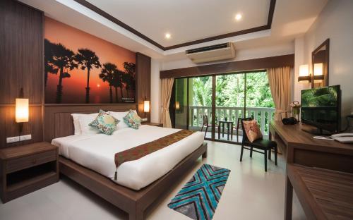 una camera con letto, scrivania e TV di Ratana Hill Patong a Patong Beach