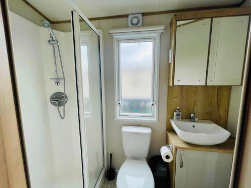 a small bathroom with a toilet and a sink at Pure-Living West Sands Sunshine and Sea View - 3 Bedroom lodge at SEAL BAY in Selsey