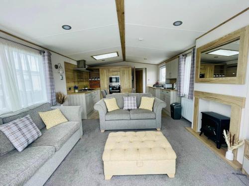 a living room with two couches and a kitchen at Pure-Living West Sands Sunshine and Sea View - 3 Bedroom lodge at SEAL BAY in Selsey