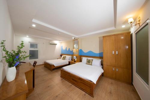 a small room with two beds and a tv at Summer Beach Hotel Vung Tau in Vung Tau