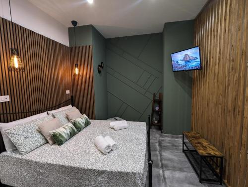 um quarto com uma cama e uma televisão na parede em Amari home em Catânia