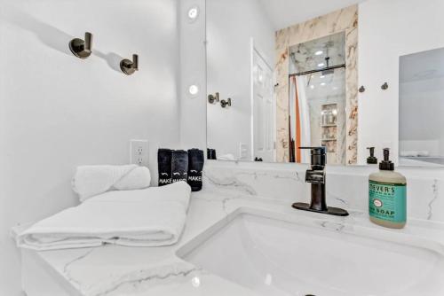 a white bathroom with a sink and a mirror at Trendy Two-Level Apartment in Buffalo
