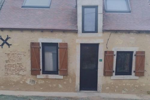 a building with wooden doors and windows on it at Le Petit Gite des sorciers, Chitray, Indre in Chitray