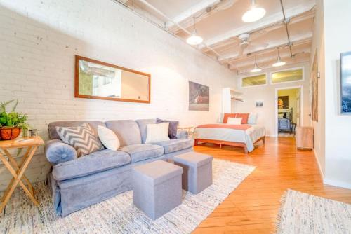 a living room with a couch and a bed at Cool Urban Stay Dtwn Apt And Patio in Binghamton