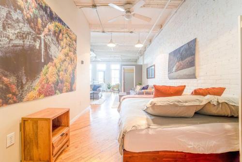 Habitación con cama y pintura en la pared en Cool Urban Stay Dtwn Apt And Patio, en Binghamton