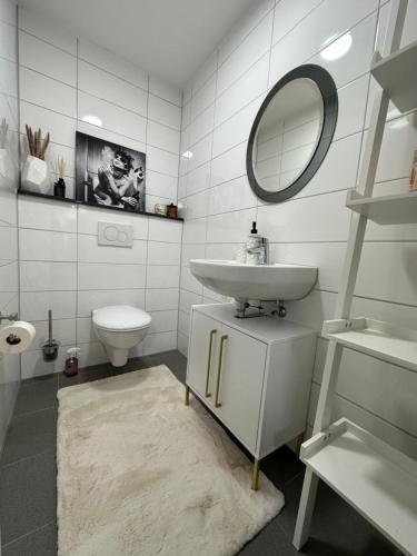 a white bathroom with a sink and a mirror at Wohnung in Laupheim in Laupheim