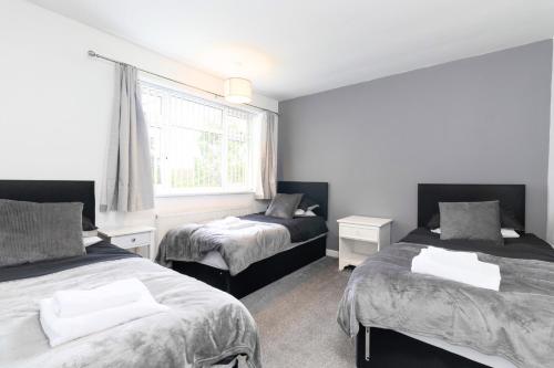 a bedroom with two beds and a window at 3 Bedroom Home with Private Driveway in Coundon