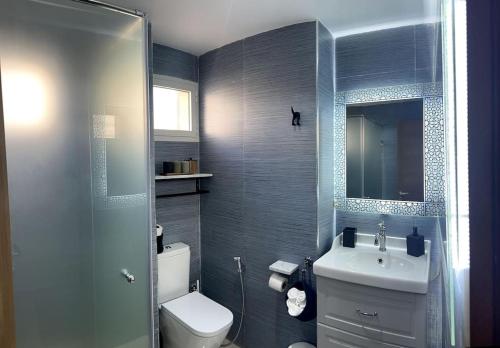 La salle de bains est pourvue de toilettes, d'un lavabo et d'un miroir. dans l'établissement Vague Bleue chez Makuja Home, à Bouznika