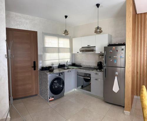 a kitchen with a stainless steel refrigerator and a dishwasher at Vague Bleue chez Makuja Home in Bouznika