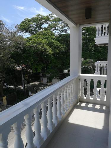 a balcony with a white railing and a window at CONDO UNIT walking distance to CALLE CRISOLOGO in Ayusan Norte
