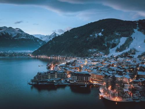 a town in the middle of a lake at night at Gästehaus Bleiweis-Zehentner in Zell am See
