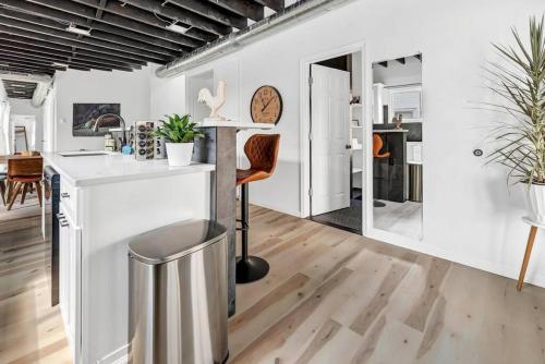 a kitchen and living room with white walls and wood floors at Cool Urban Stay Downtown Loft in Buffalo