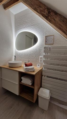 a bathroom with a sink and a mirror at Meublé 5* Au gré des saisons in La Baconnière