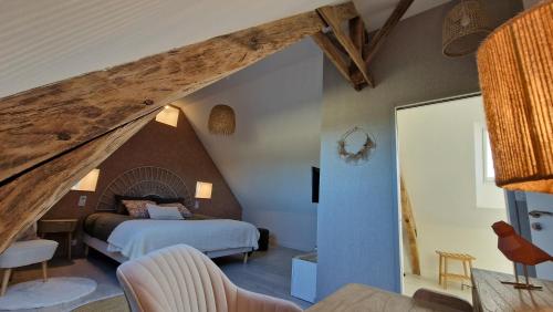 a bedroom with a bed in a attic at Meublé 5* Au gré des saisons in La Baconnière
