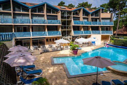 hotel z basenem, leżakami i parasolami w obiekcie Hotel Logis Lacotel w mieście Soorts-Hossegor