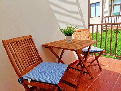 a table and two chairs with a potted plant on a porch at Casa Perla - Cerca de la playa in Playa de Santiago