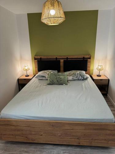 une chambre avec un grand lit avec deux tables de nuit dans l'établissement Appartement cosy et lumineux dans village medieval, à Boulieu-lès-Annonay