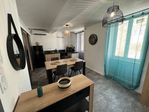 Habitación con mesa, sillas y cocina. en Appartement cosy et lumineux dans village medieval en Boulieu-lès-Annonay