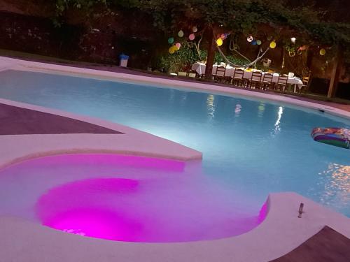 a swimming pool with pink lights in the water at Casa da Rapadoira 