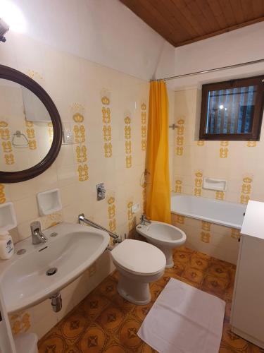 y baño con aseo blanco y lavamanos. en La Finestra sui Monti - Alpine Stay Apartments, en Cavalese