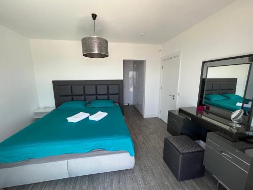 1 dormitorio con cama azul y espejo en Villa Aylinda with private heated Pool, en Bodrum City