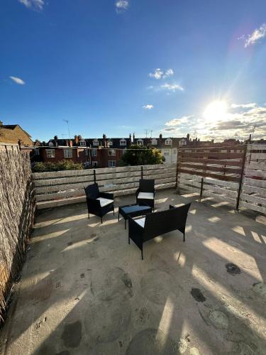 three chairs and a table on a patio at Entire 3 Bedroom Apartment in Felixstowe in Felixstowe