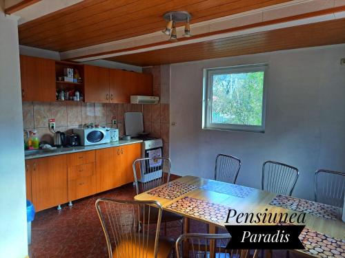a kitchen with a table and chairs in a room at Pensiunea Paradis in Buşteni