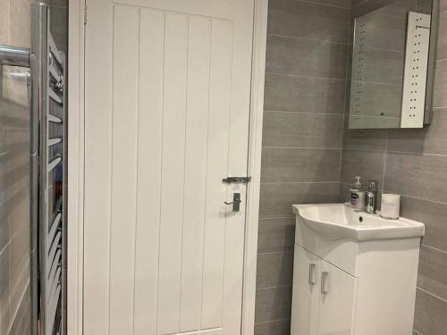 a bathroom with a white cabinet and a sink at Beautiful Cottage in Ashbourne in Ashbourne