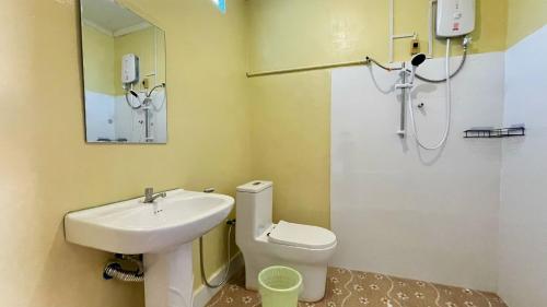 een badkamer met een wastafel, een toilet en een spiegel bij Moukdavan Guesthouse in Luang Prabang