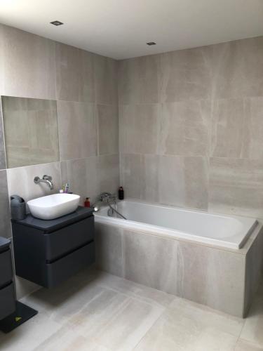 a bathroom with a white tub and a sink at Enjoyvilla@sea in Ostend