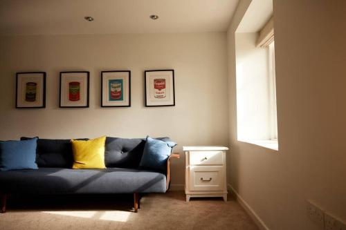 a living room with a blue couch and a window at Vine Cottage in Shepton Mallet
