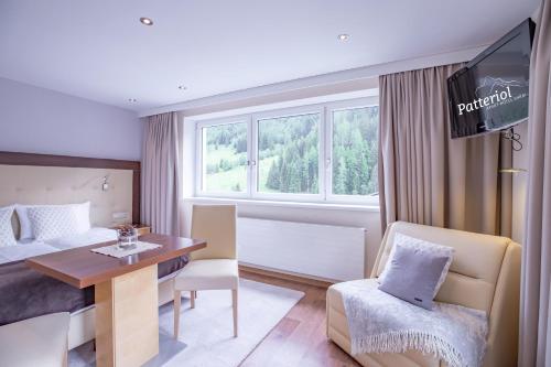 Habitación de hotel con cama, mesa y silla en Patteriol Apart-Hotel-Garni en Sankt Anton am Arlberg