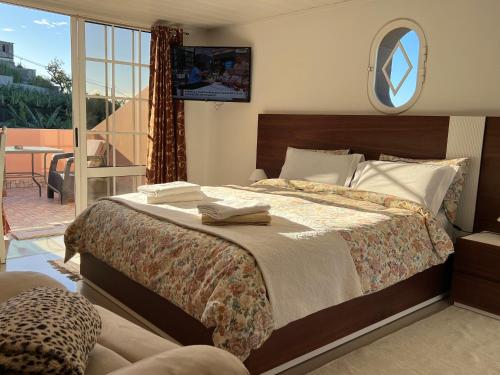 1 dormitorio con 1 cama grande y balcón en Villa Formosa, en Funchal