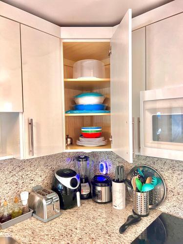 a kitchen with white cabinets and a counter top at The Boutique Guest House in Miami