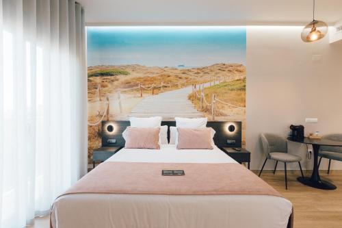 ein Schlafzimmer mit einem großen Bett mit einem Gemälde eines Strandes in der Unterkunft Palau Apartments Valencia in Valencia