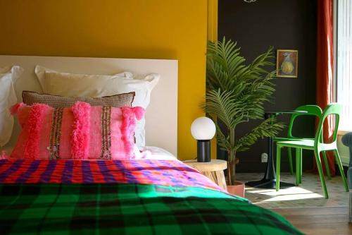 a bedroom with a bed with colorful pillows on it at Saint Michel - Centre Ville - Espace Coty in Le Havre
