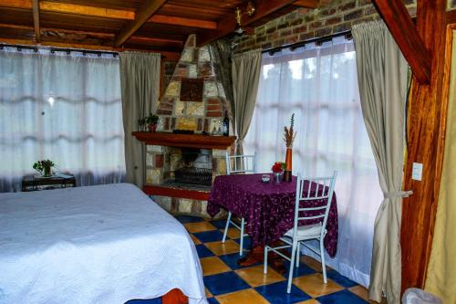 a bedroom with a bed and a table and chairs at Tu Casa - Hotel Rural in Sopó