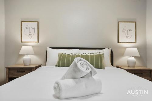 a bedroom with a white bed with towels on it at Spacious 2 Apt Combo Sleeps 12 Pool and Pets in Austin