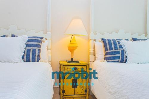 ein Schlafzimmer mit 2 Betten und einer Lampe auf einem Nachttisch in der Unterkunft Hermoso y perfecto 2 Hab frente al mar en Cap Cana in Punta Cana