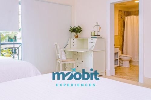 a bedroom with a white bed and a desk at Hermoso y perfecto 2 Hab frente al mar en Cap Cana in Punta Cana