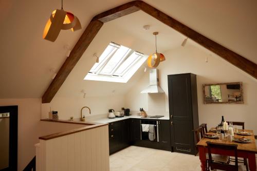 an attic kitchen with a sink and a window at The Old Winery Cottage No2 in Shepton Mallet