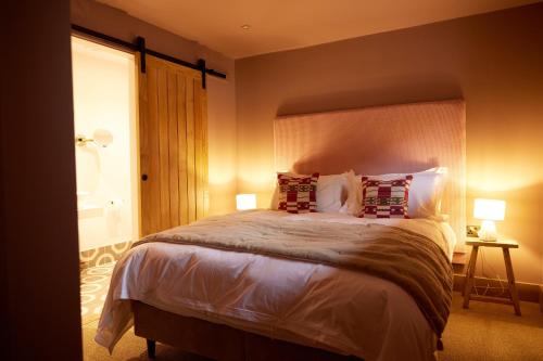 a bedroom with a large bed with two lamps at The Old Winery Cottage No2 in Shepton Mallet